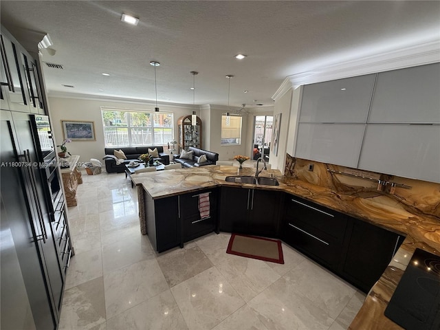 8389 NW 115th Ct, Doral, FL 33178 - kitchen featuring ornamental molding, open floor plan, dark cabinetry, a sink, and a peninsula