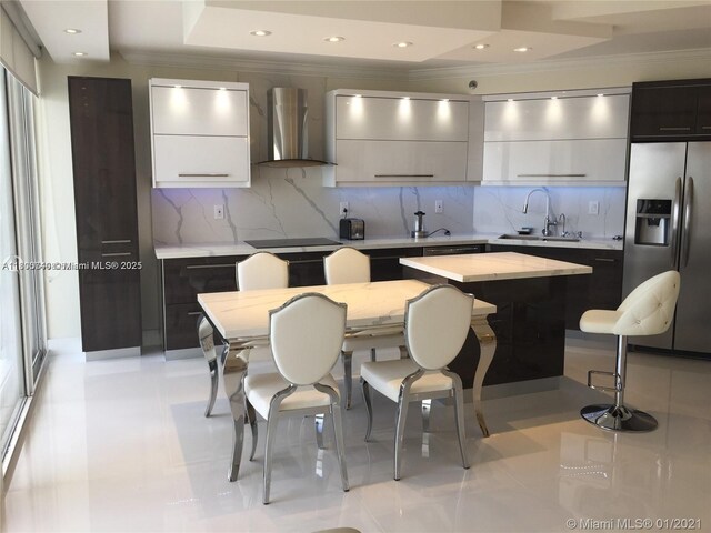 16485 Collins Ave Unit 538, Sunny Isles Beach, FL 33160 - kitchen featuring stainless steel fridge, wall chimney exhaust hood, a sink, modern cabinets, and ornamental molding