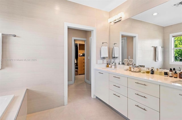 164 W Mashta Dr, Key Biscayne, FL 33149 - bathroom with double vanity, tile patterned floors, a walk in closet, tiled tub, and baseboards
