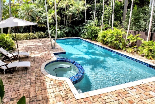 164 W Mashta Dr, Key Biscayne, FL 33149 - view of pool with a pool with connected hot tub, a patio, and view of scattered trees