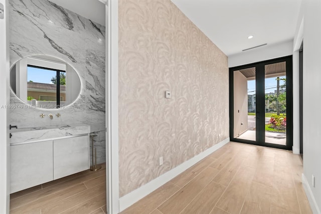 hall featuring wood finished floors, healthy amount of natural light, and baseboards