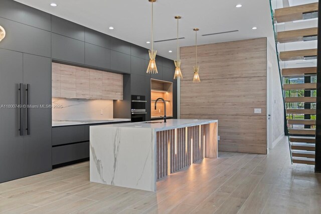 kitchen featuring a sink, modern cabinets, recessed lighting, light countertops, and wood walls