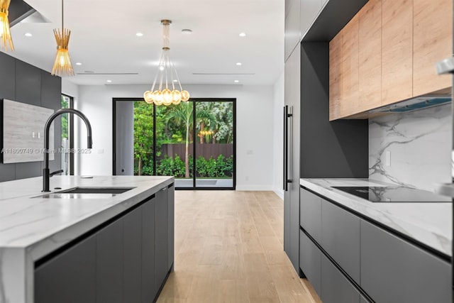 kitchen featuring a sink, modern cabinets, tasteful backsplash, recessed lighting, and light stone counters