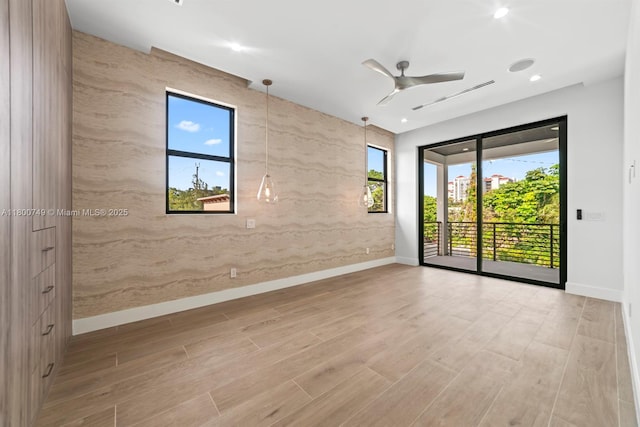 spare room featuring a ceiling fan, baseboards, wood finished floors, and recessed lighting