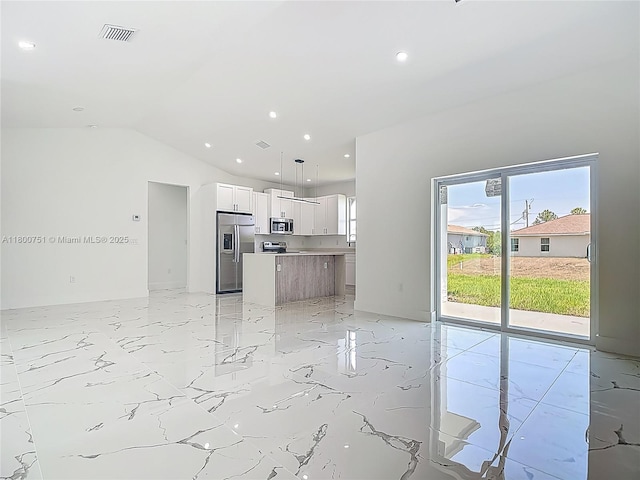 unfurnished living room with healthy amount of natural light, recessed lighting, lofted ceiling, and light marble finish floors