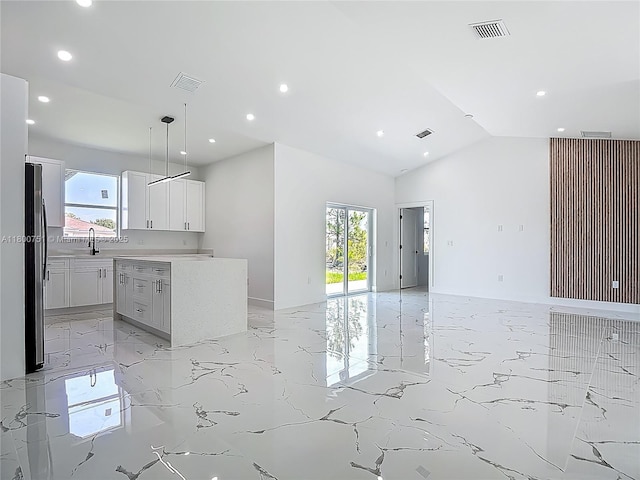 kitchen featuring light marble finish floors, open floor plan, recessed lighting, healthy amount of natural light, and a sink