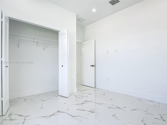 unfurnished bedroom with light marble finish flooring, a closet, recessed lighting, and baseboards