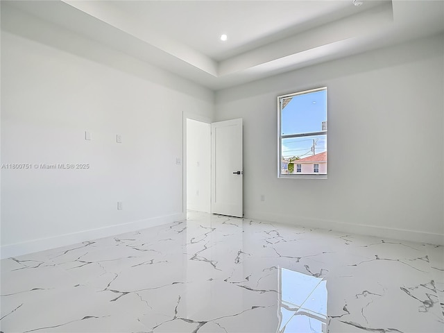 empty room featuring baseboards, light marble finish floors, and recessed lighting