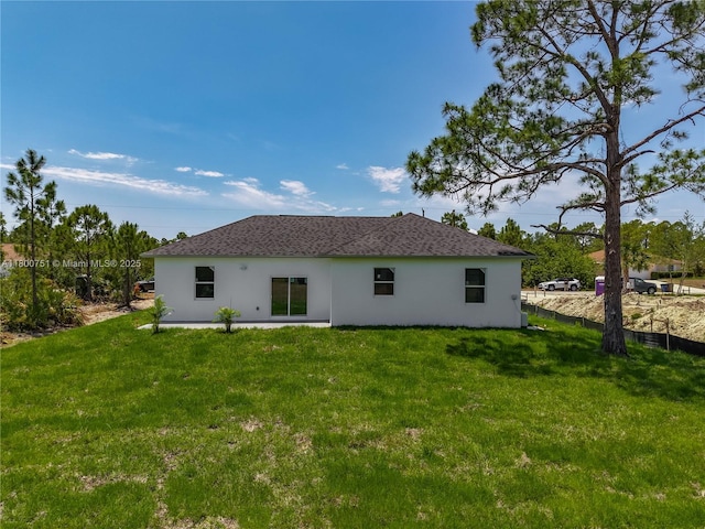 rear view of house featuring stucco siding