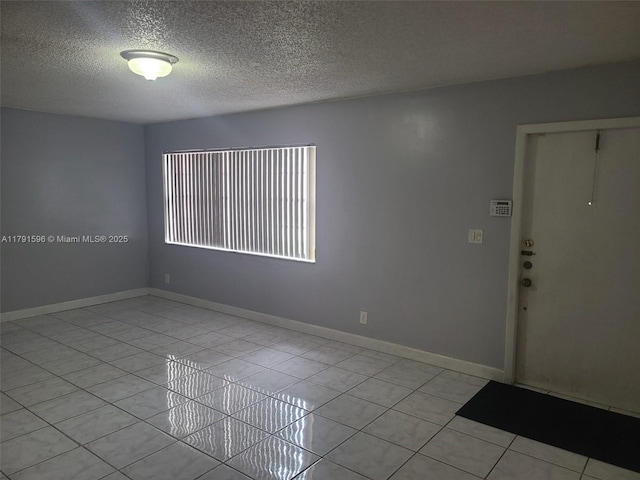 29 Seville Cir Unit 4-49, Davie, FL 33324 - empty room with a textured ceiling, light tile patterned flooring, and baseboards