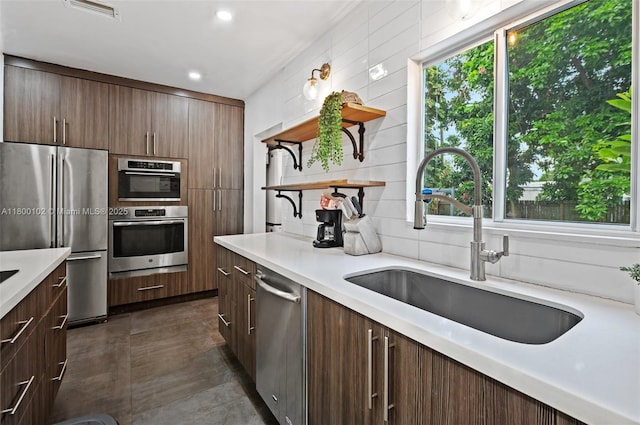 534 NW 50th St, Miami, FL 33127 - kitchen featuring stainless steel appliances, open shelves, a sink, light countertops, and recessed lighting