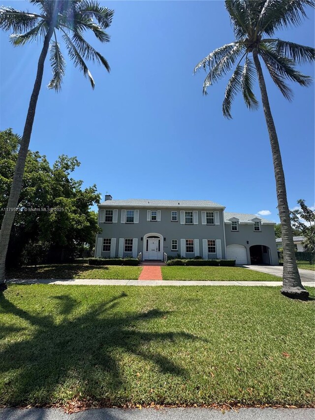 1234 NE 96th St, Miami Shores, FL 33138 - view of front of property featuring a garage, a front yard, stucco siding, and driveway