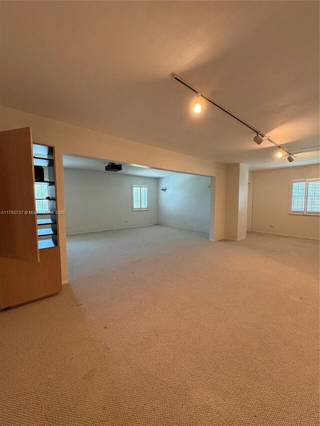 1234 NE 96th St, Miami Shores, FL 33138 - below grade area with rail lighting, carpet floors, and healthy amount of natural light