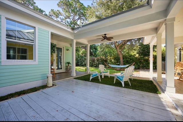 wooden terrace featuring ceiling fan and a patio area
