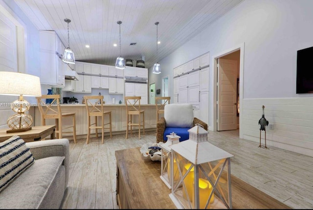 living area with wooden ceiling, light wood finished floors, a wainscoted wall, and recessed lighting