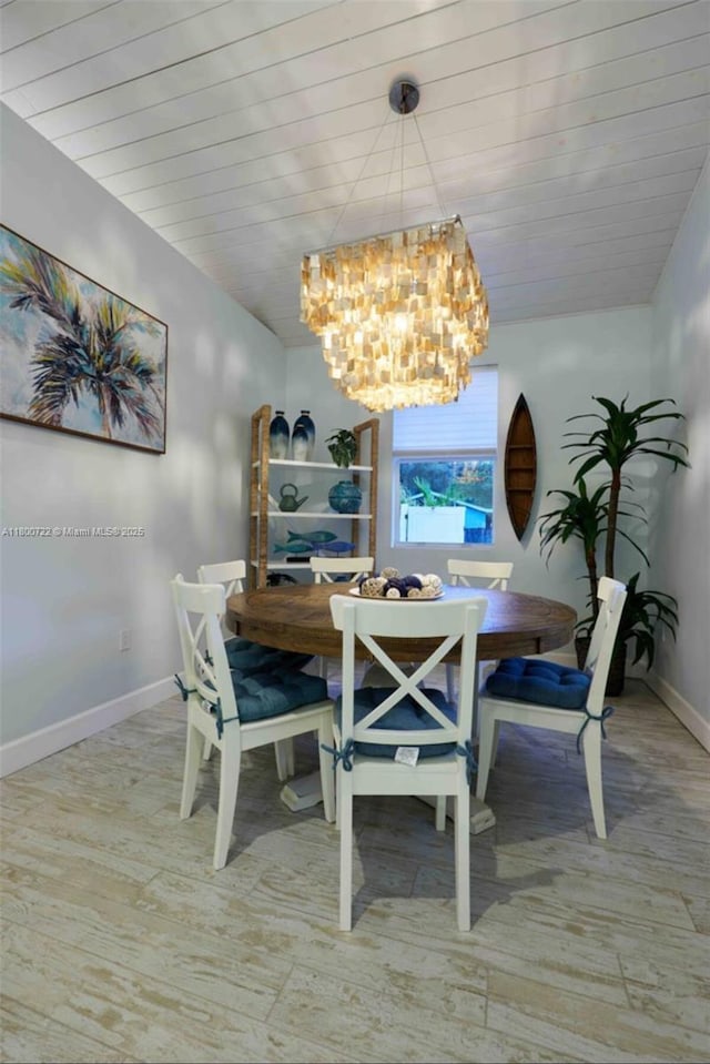 dining area with a chandelier, baseboards, and wood finished floors