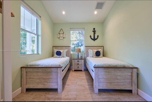bedroom with wood finished floors, baseboards, and recessed lighting