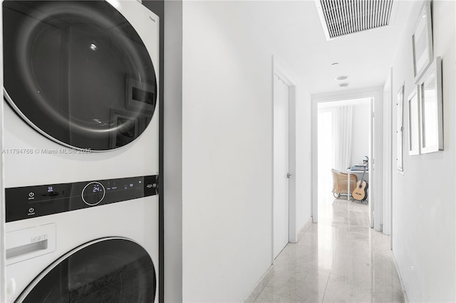 495 Brickell Ave Unit 1001, Miami, FL 33131 - washroom with stacked washer and clothes dryer, baseboards, and light marble finish flooring