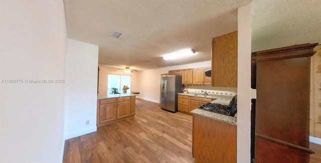 4878 Messana Ter, Lake Worth, FL 33463 - kitchen featuring stainless steel fridge, light wood-type flooring, baseboards, light countertops, and a textured ceiling