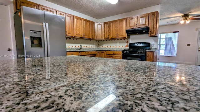4878 Messana Ter, Lake Worth, FL 33463 - kitchen featuring stainless steel refrigerator with ice dispenser, black range with gas stovetop, under cabinet range hood, a ceiling fan, and a textured ceiling