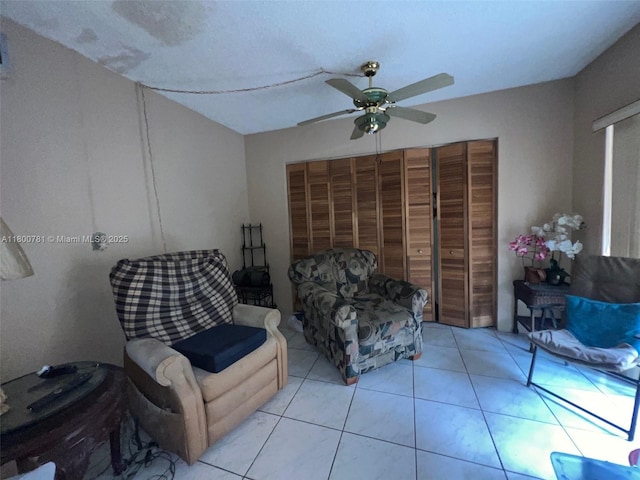 sitting room with ceiling fan and tile patterned floors