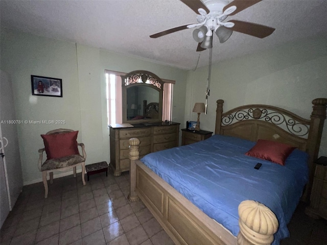 tiled bedroom featuring a textured ceiling, ceiling fan, and baseboards