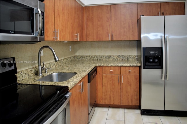 3300 NE 192nd St Unit 611, Aventura, FL 33180 - kitchen featuring appliances with stainless steel finishes, a sink, light stone counters, and brown cabinets