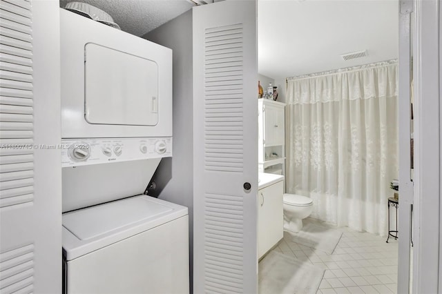 1500 SW 131st Way Unit 401N, Pembroke Pines, FL 33027 - washroom featuring stacked washer / dryer and light tile patterned floors