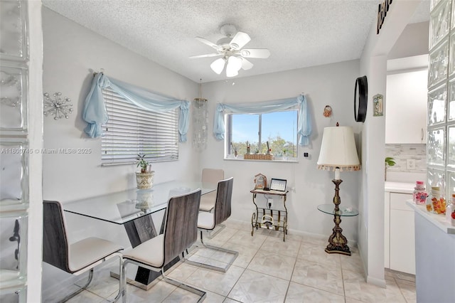 dining area featuring ceiling fan and a textured ceiling