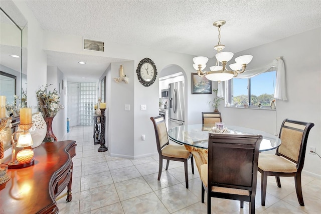 1500 SW 131st Way Unit 401N, Pembroke Pines, FL 33027 - dining space featuring a chandelier, arched walkways, a textured ceiling, and baseboards