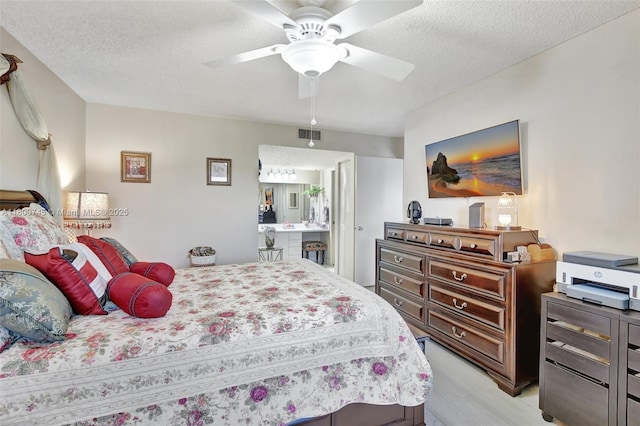 bedroom featuring light wood finished floors, a textured ceiling, and a ceiling fan