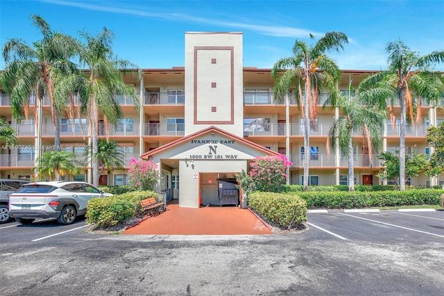 view of apartment building / complex featuring uncovered parking