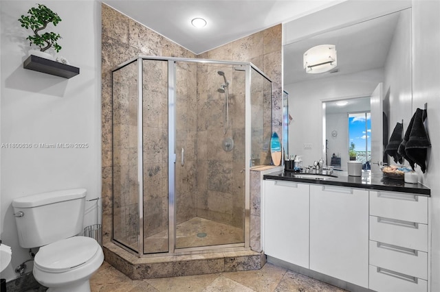 full bath with a stall shower, vanity, and toilet