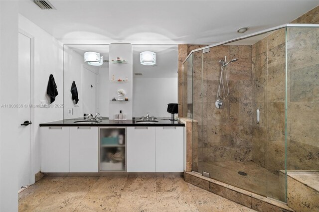 bathroom with a stall shower and double vanity