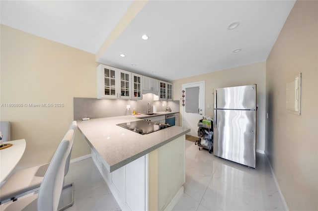 kitchen featuring freestanding refrigerator, black electric stovetop, light marble finish flooring, baseboards, and dishwasher