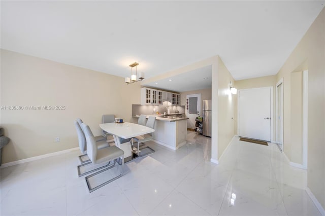 dining space featuring baseboards and a chandelier