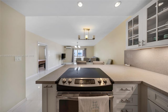 kitchen with stainless steel electric range, glass insert cabinets, open floor plan, a peninsula, and baseboards