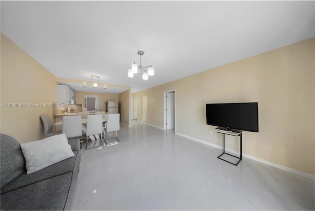 living room with light marble finish flooring, a chandelier, and baseboards