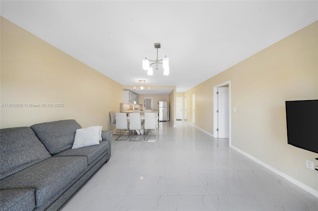 living room with a chandelier, light marble finish floors, and baseboards