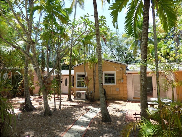 back of house with a cooling unit, a patio area, and brick siding