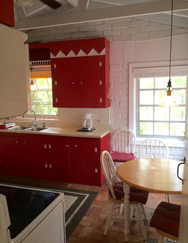 5858 SW 80th St, South Miami, FL 33143 - kitchen with brick flooring, a sink, electric range oven, and red cabinets