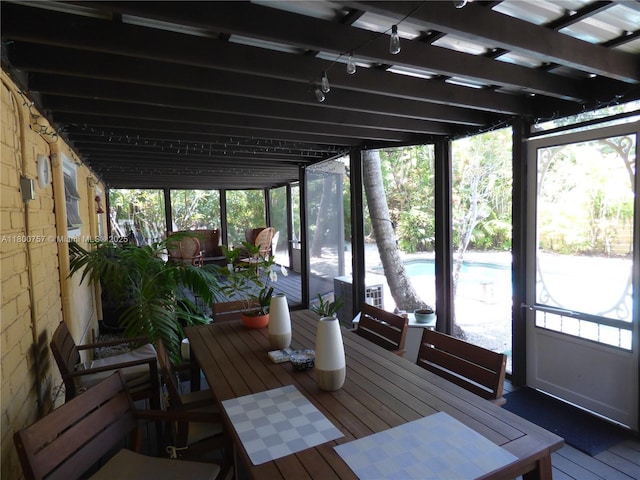 sunroom / solarium featuring plenty of natural light and outdoor dining area