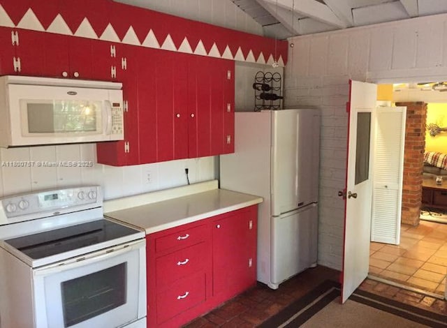 kitchen featuring white appliances, red cabinetry, and light countertops
