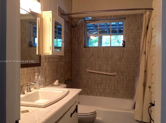 full bath featuring tile walls, shower / tub combo, vanity, toilet, and tasteful backsplash