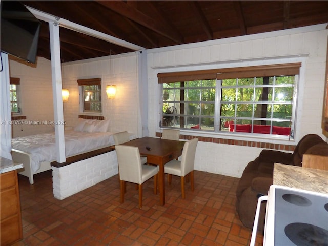 bedroom with beamed ceiling, brick floors, and wood ceiling