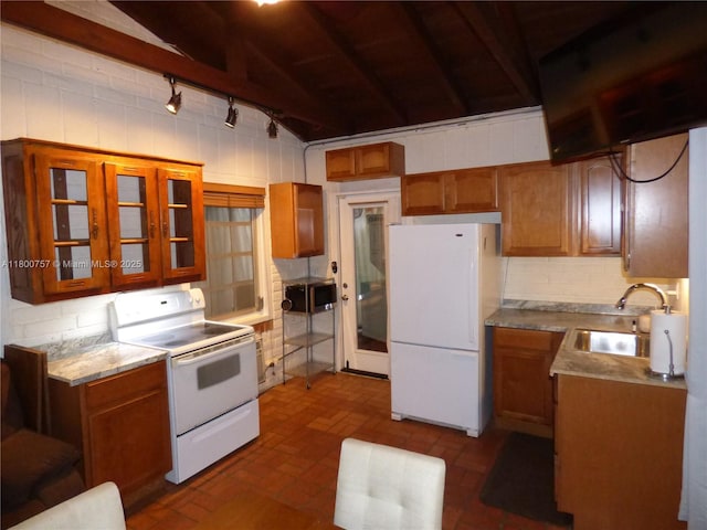 kitchen with white appliances, a sink, backsplash, brown cabinets, and glass insert cabinets