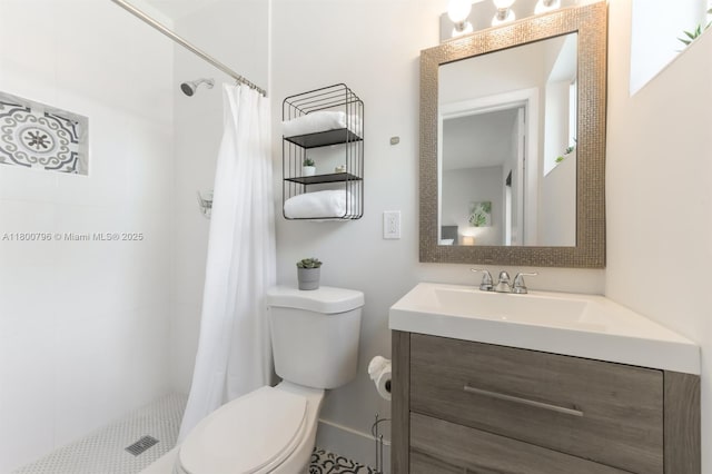 bathroom featuring toilet, a tile shower, and vanity