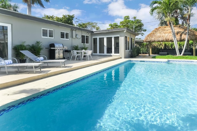 outdoor pool with a grill, a patio, a gazebo, and french doors