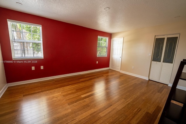 12840 SW 146th Ln, Miami, FL 33186 - spare room featuring hardwood / wood-style flooring, a textured ceiling, healthy amount of natural light, and baseboards