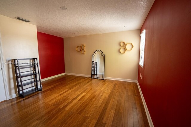 12840 SW 146th Ln, Miami, FL 33186 - empty room featuring a textured ceiling, wood finished floors, and baseboards